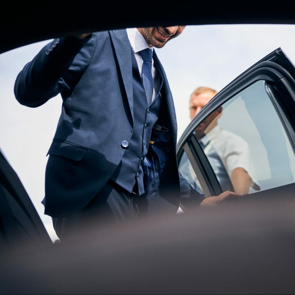 cheerful businessman getting into a backseat of a 2021 09 03 21 03 26 utc e1671605090508