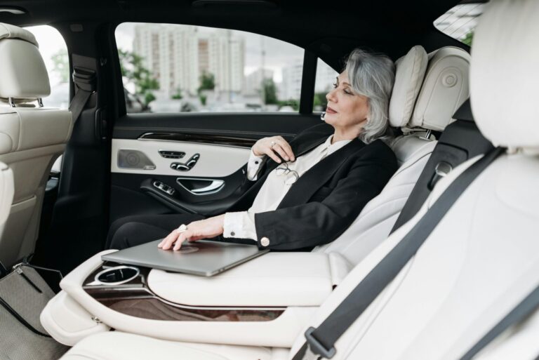 businesswoman in a black suit sitting in the backseat of a car