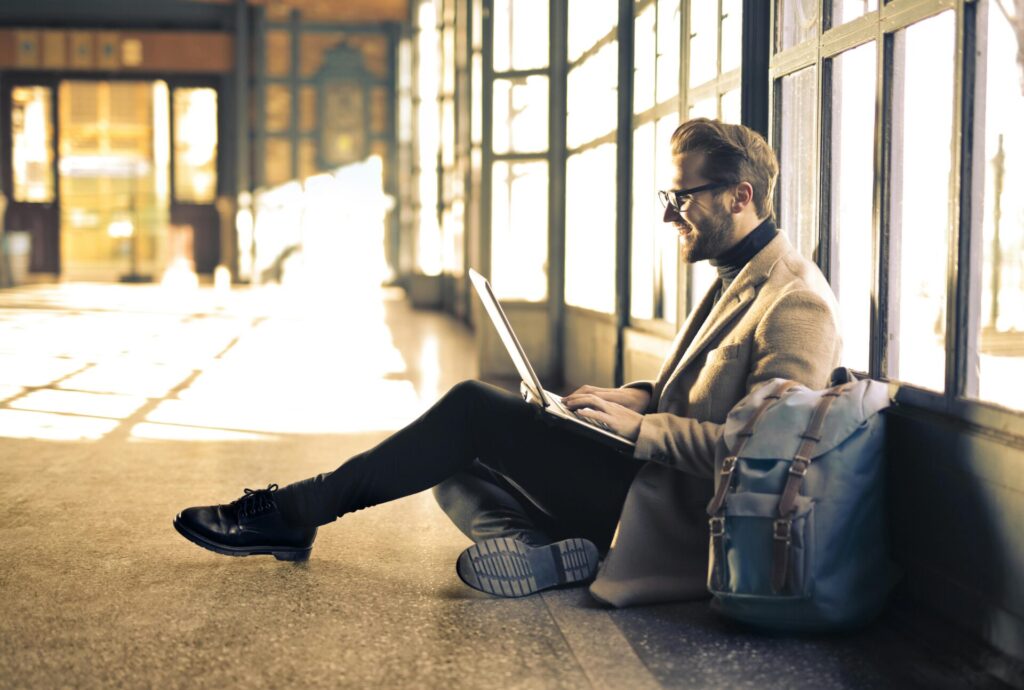 man on computer in airport